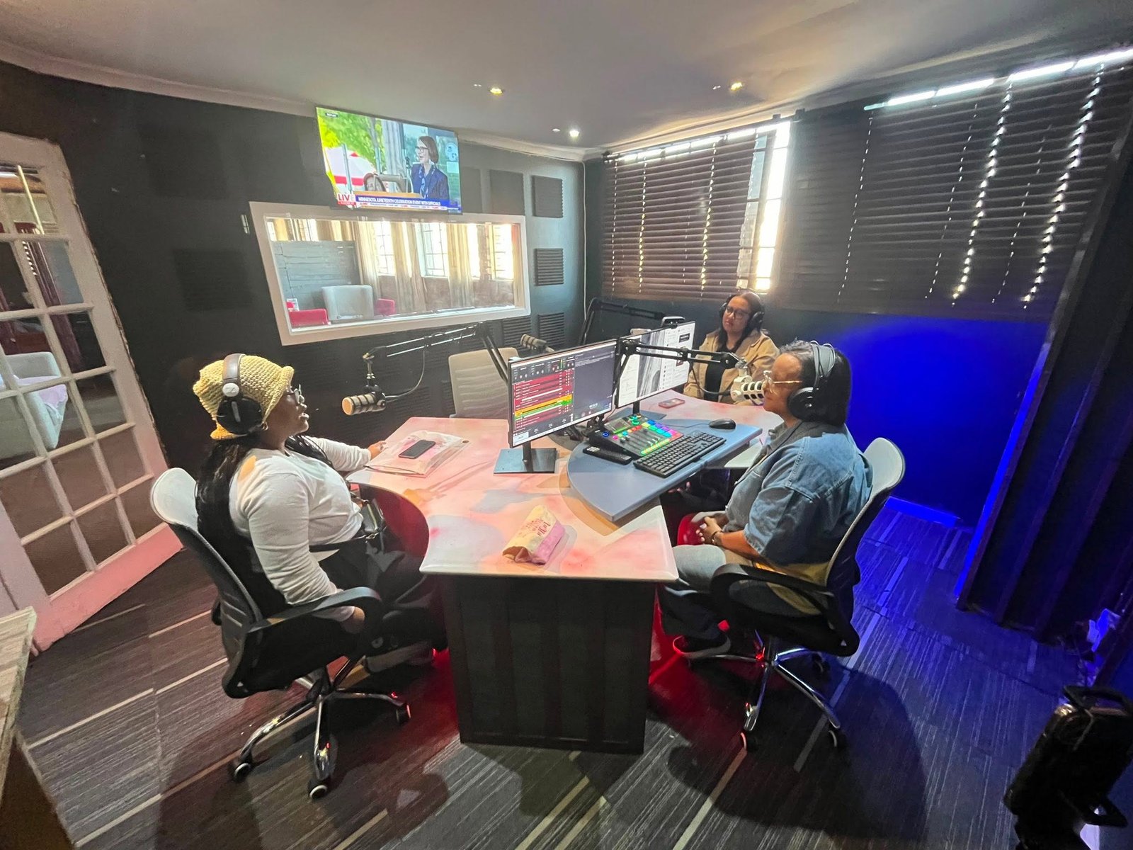 Three Inspire Digital Radio presenters seated around the studio desk during a live broadcast